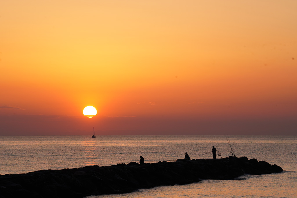Bucólico
Siluetas de pescadores, un barco de vela que inicia la navegación a primera hora de la mañana , y el sol inundando de luz, este amable mar mediterráneo. 

