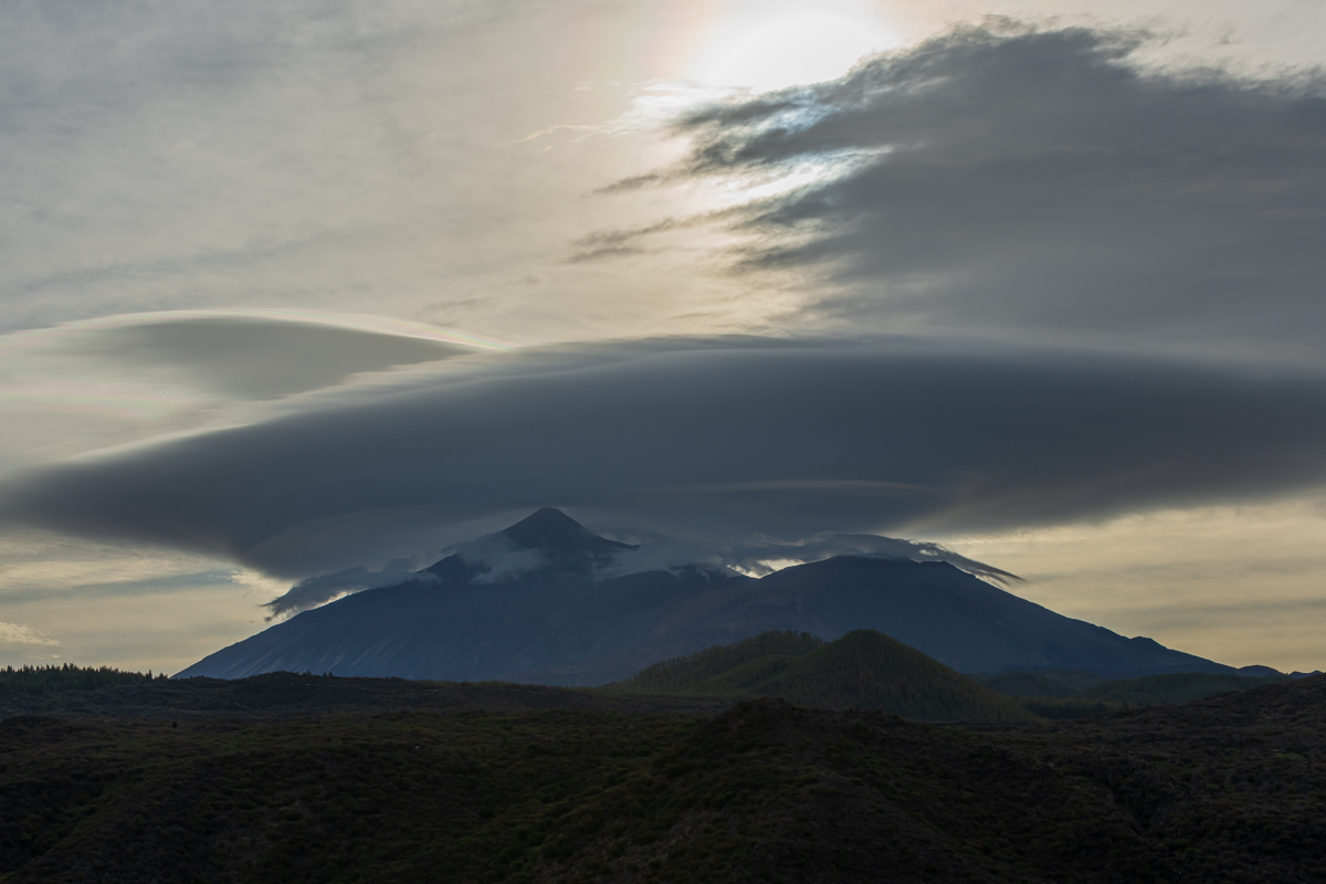 Una gigantesca nube lenticular mantiene atrapadas algunas nubes fantasmas que intentar escapar.
