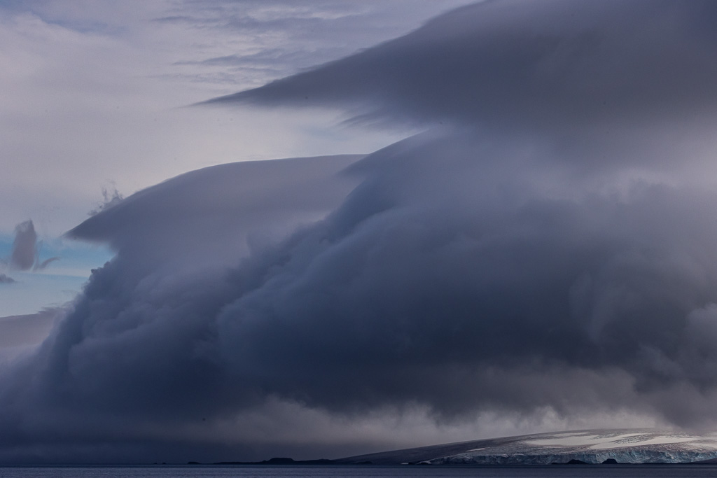 Grandes nubes sobre las islas shetland del sur (antártica)
Durante una navegación por el estrecho de Bransfield en cercanías de Bahia Fildes, logro apreciar unas grandes nubes donde algunas tenian forma de lenticular que acompañaban al terreno blanco de la antártica 
