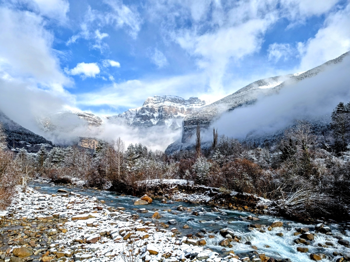 Fotografía tomada tras una nevada reciente. Se observan estratos en las laderas y al fondo de la imagen, quedando un paisaje idílico con la nieve.
