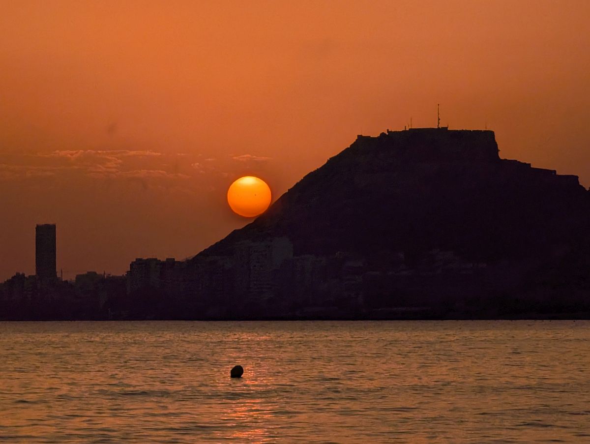 Puesta de sol en Alicante, en el Monte Benacantil y el castillo de Santa Bárbara, fotografía desde la playa de la Almadraba
