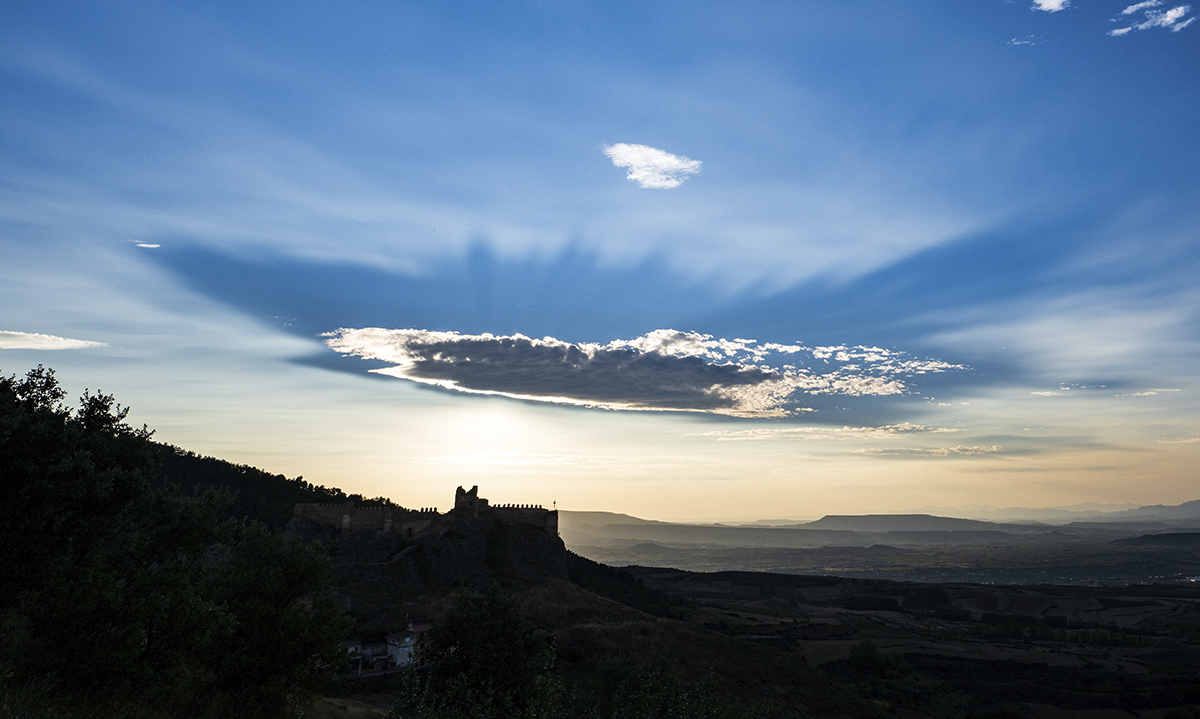 Sobre el milenario castillo de Clavijo del siglo X, se apaga el sol al atardecer y especialmente sobre ese cielo compuesto con unas nubes que parecían diseñadas para engrandecer aún más esa escena.
