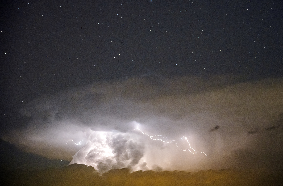 Final del verano y comienzan los cambios en la atmósfera. Un núcleo de tormenta y los rayos se concentran bajo un cielo limpio y estrellado en altura.
