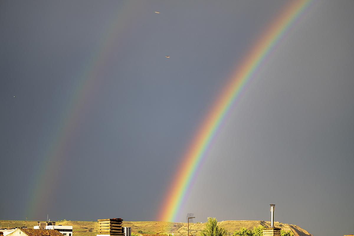 Tras la intensa lluvia, el sol luce con fuerza y descubre unos intensos colores de arcoiris sobre el cielo de Logroño
