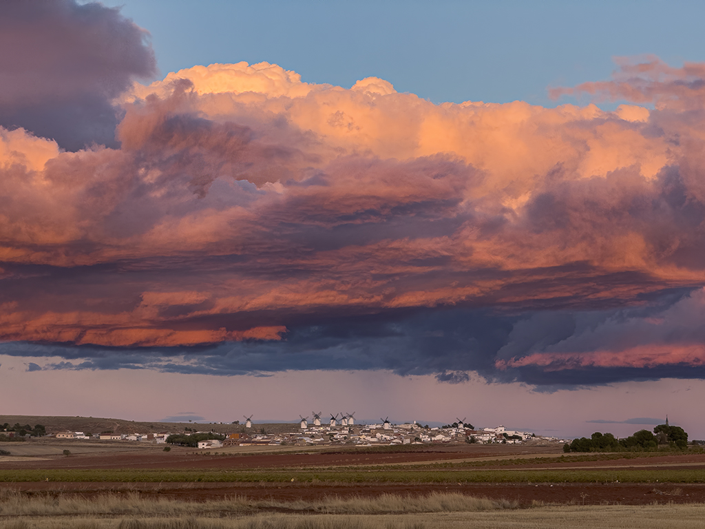 Cinco minutos antes de ponerse el sol hice esta fotografía con ese tono malva que se produce en las nubes que están opuestas al sol en su ocaso. Una nube que cubría mi pueblo en su totalidad, aunque no le afectaba su sombra al estar ya casi poniéndose el sol.
