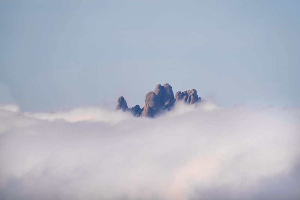 Algunas de las agujas de Montserrat emergen entre las nubes como si flotaran en el cielo.
