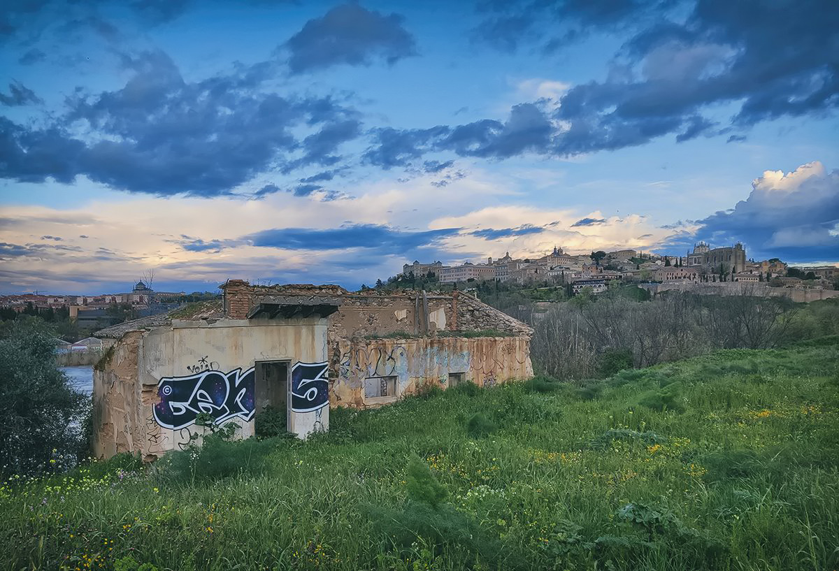 Bajo un manto de nubes, a las orillas del Tajo, se yergue hermosa la ciudad de Toledo.
