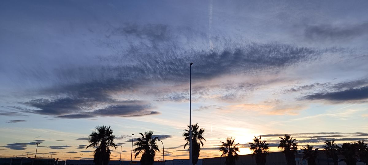 Nube singular captada con forma de ballena bajo el cielo del atardecer, tintando su superficie de azul oscuro y su 'tripa' de color claro.
