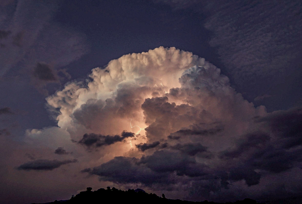 cumulonimbus capillatus el 10-septiembre-2023 a última hora de la tarde desde el embalse de Navacerrada. La nube quedaba iluminada en su parte interior por las descargas eléctricas casi continuas que se producían, y en su parte superior por el efecto Alpengluhen, con los últimos rayos solares iluminándo dicha parte. La tormenta dejo granizo de tamaño considerable que llegó a cubrir el suelo
