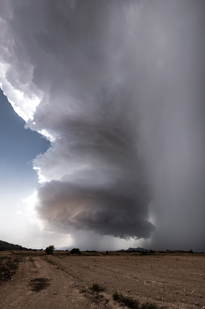 Domingo 25 de agosto, partimos de nuestra ubicación en Águilas a las 13:00 del medio día, llegando al noroeste de la región de Murcia sobre las 14:30. A estas horas ya surgían las primeras tormentas en Nerpio (Albacete) aunque desde la distancia se veían muy difuminadas debido a la presencia de calima.
Conforme avanzaron los minutos estos mismos núcleos se fueron intensificando y desplazándose dirección sur entrando a la región de Murcia y altiplano Granadino. Una vez en las tierras altas de Caravaca se empezaba a observar una estructura que hacia presagiar lo que finalmente sucedió, una supercelula brutal en donde se apreciaba de una manera muy nítida la rotación que hacían las nubes en su camino a la provincia de Almería. Dejó granizo de gran tamaño, midiéndose en algunos puntos hasta 7 cm, provocando daños en vehículos, tejados y árboles. 

He escogido "Rotación al límite" como titulo de la foto debido a la clásica rotación que se deja ver en las supercelulas y "al límite" por que surgió, se intensifico y se desplazó entre los limites de tres provincias.
