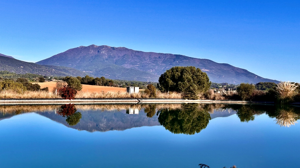 Una balsa de agua junto a un cielo azul, crean un mágico reflejo del Parque Natural del Montseny.
