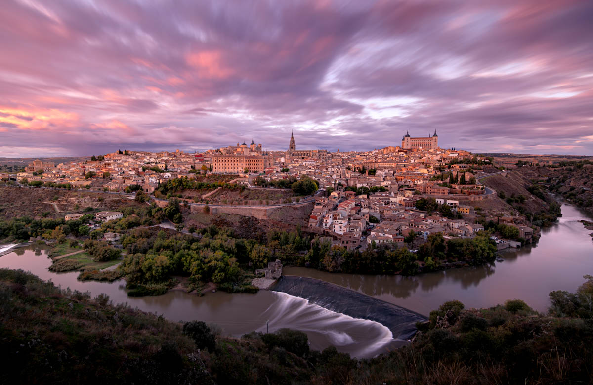 Manto de nubes en movimiento al atardecer, teñidas por los últimos rayos del sol en Toledo
