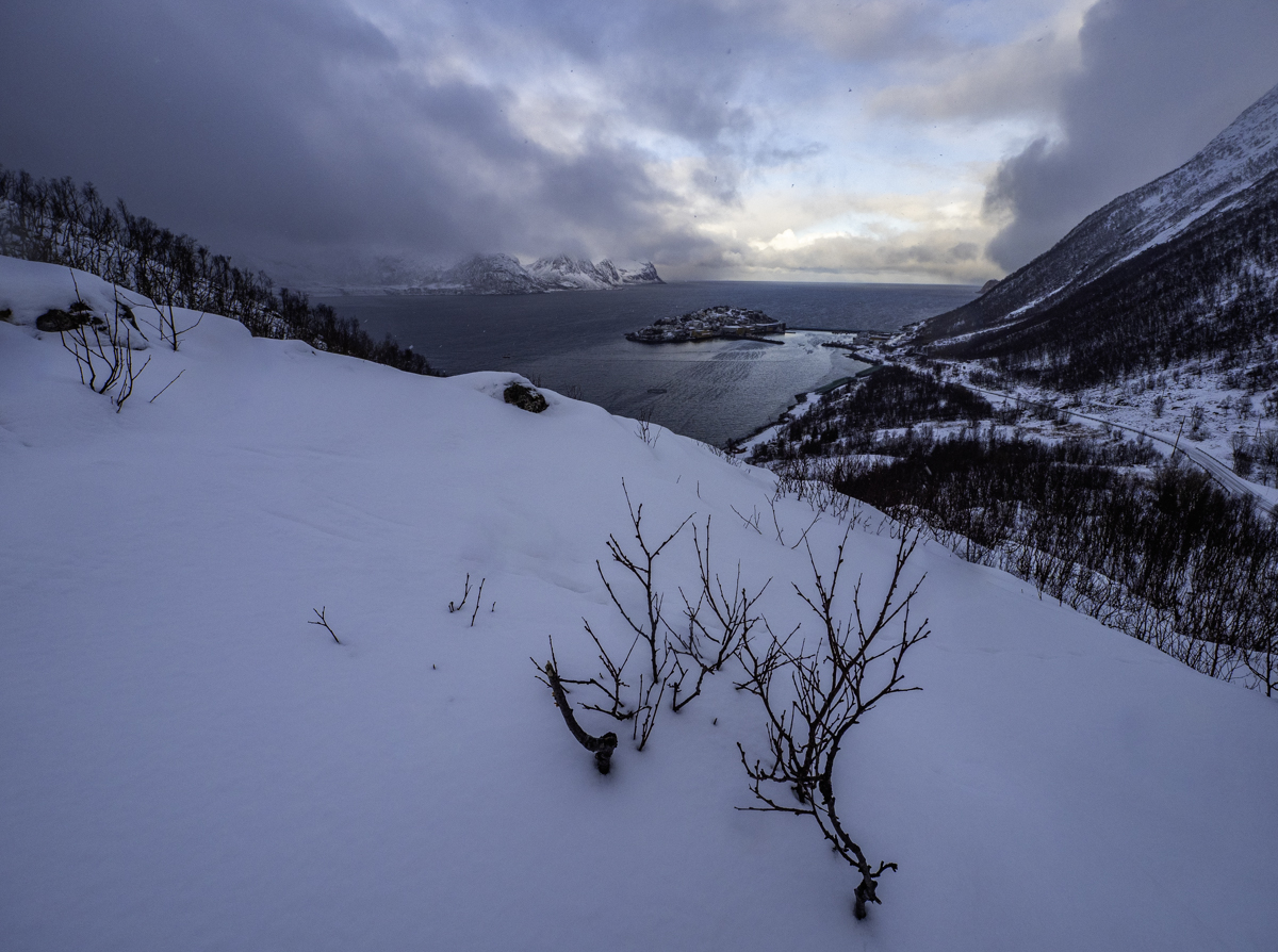 Atardecer de frentes de lluvia y nieve que se deslizan en el fiordo engullendo la isla.
