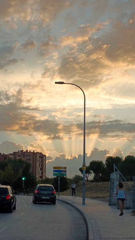 Iba yo caminando por la calle cuando de pronto me encuentro este atardecer despues que pasara dias lloviendo con esos haces de luz que parecian que detras de las nubes se estuviera desarrollando una fiesta donde no podriamos acceder.
