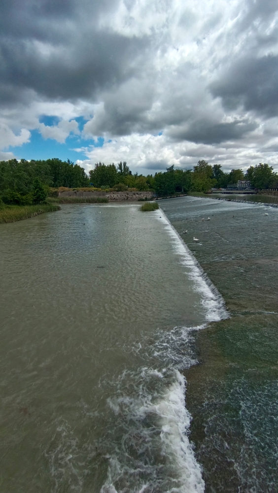 Y en otro momento visitando una pequeña isla que construyeron en Aranjuez nos deja esta gran foto donde vemos las nubes revoloteando sin saber que hacer opacando el cielo azul y creando una imagen magica con el la caida del agua
