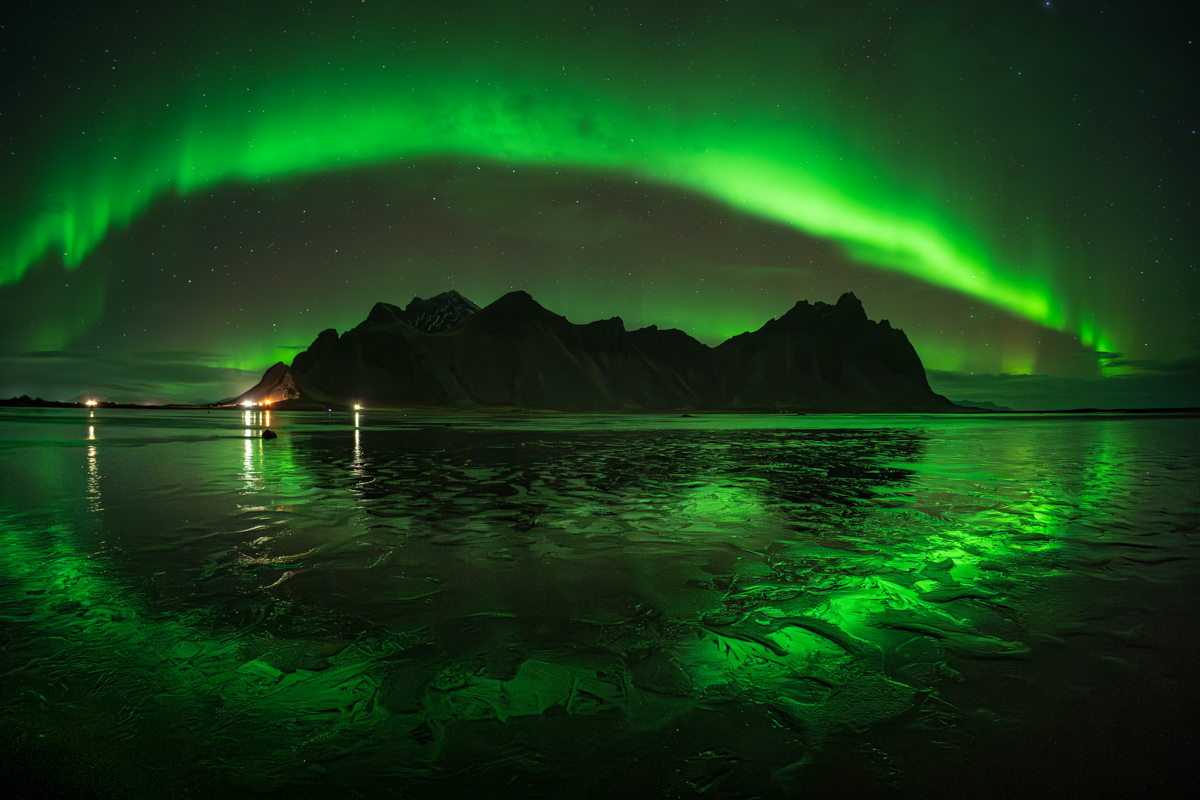 Arco de aurora boreal en Stokssness, Islandia. La playa de arena negra fetiche para muchos fotógrafos, de noche se conviere en un espejo espectacular reflejando la aurora boreal.
