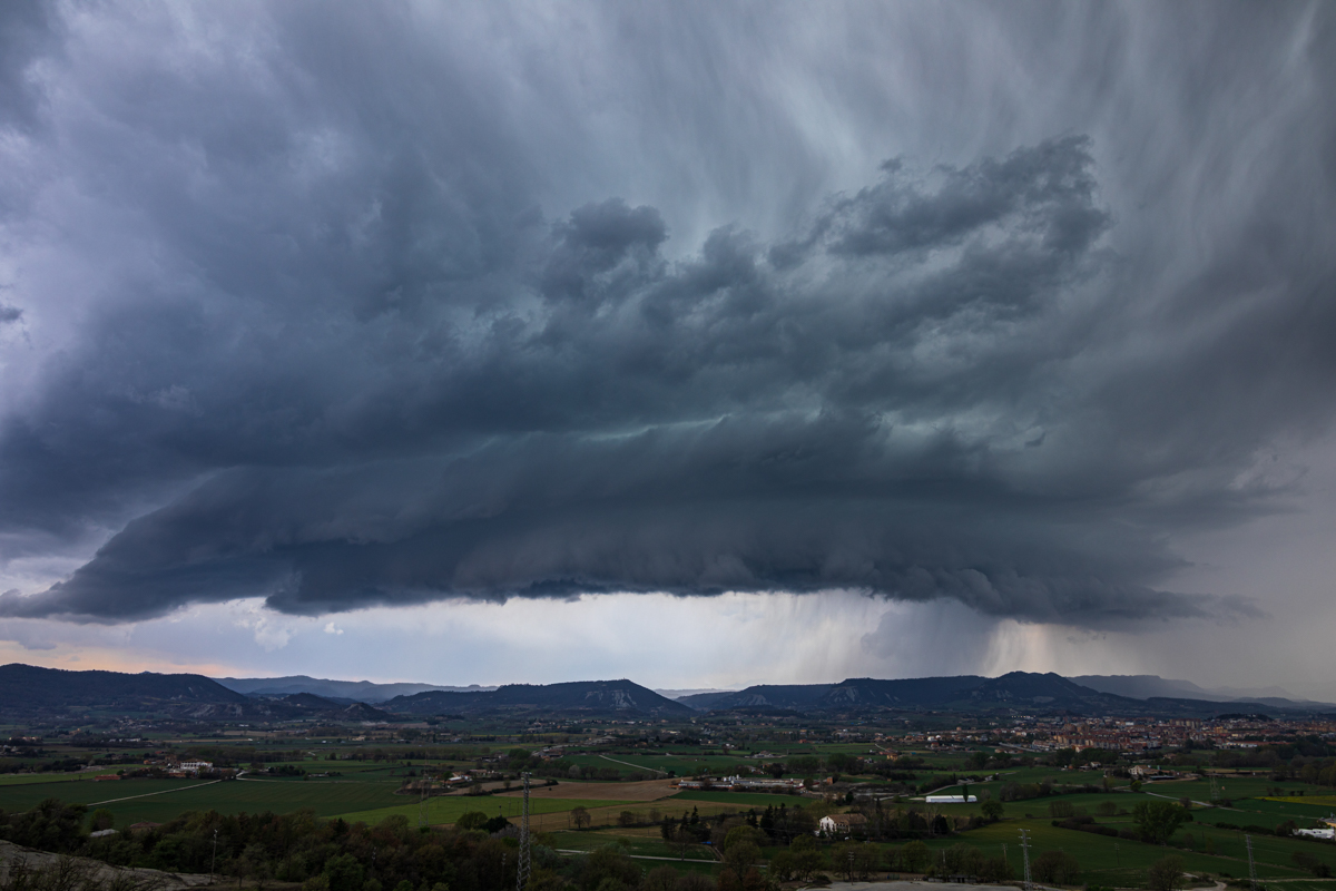 Enfrente de mí. Ese día pude observar como la tormenta se formaba en el horizonte e iba cogiendo cuerpo y estructura. La foto refleja el momento que entra en Osona, mostrando toda su belleza y fuerza.
