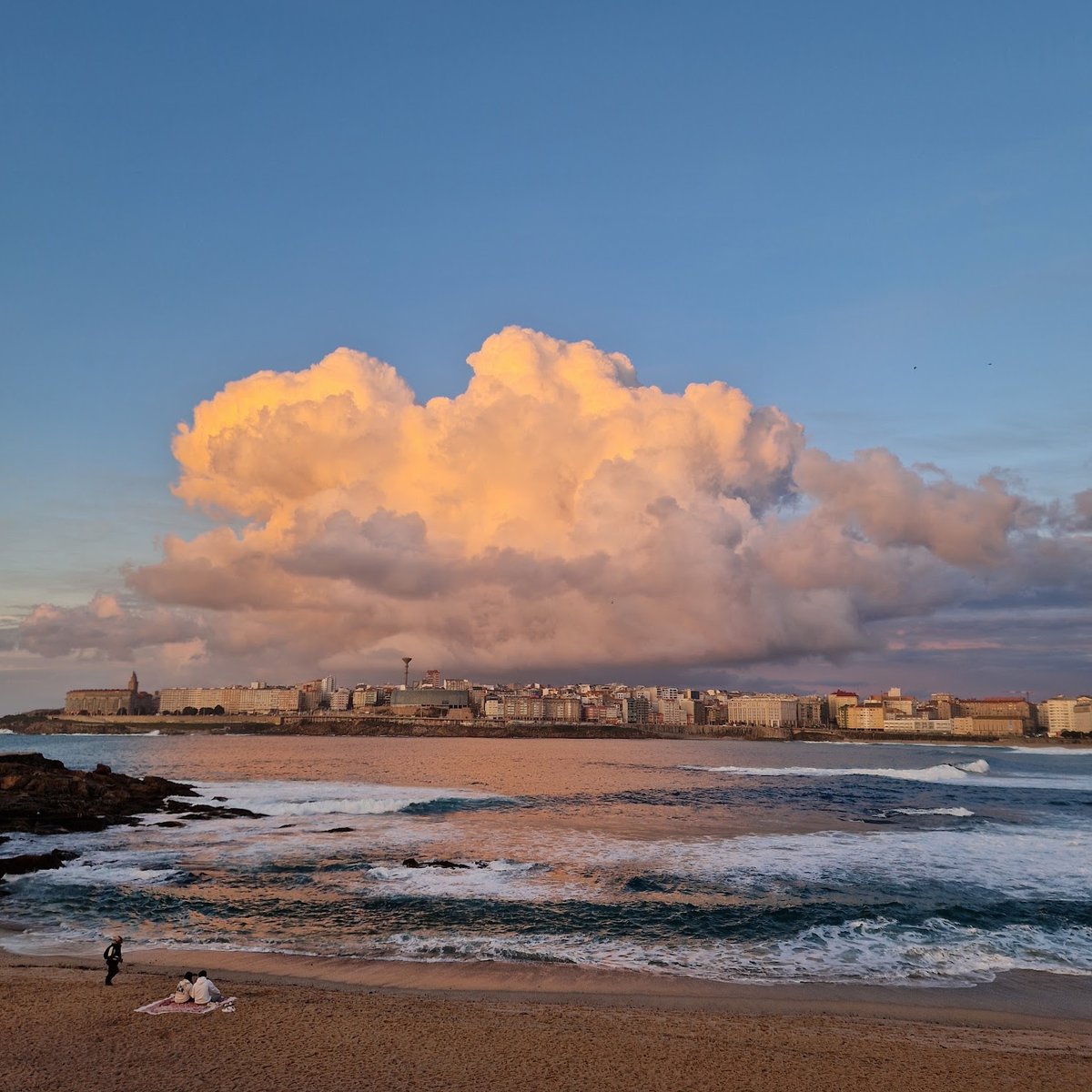 Nube iluminada por la luz del atardecer sobre la playa de A Coruña.

